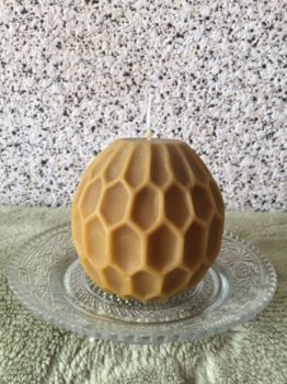 Świeca z naturalnego wosku pszczelego w kształcie kuli.